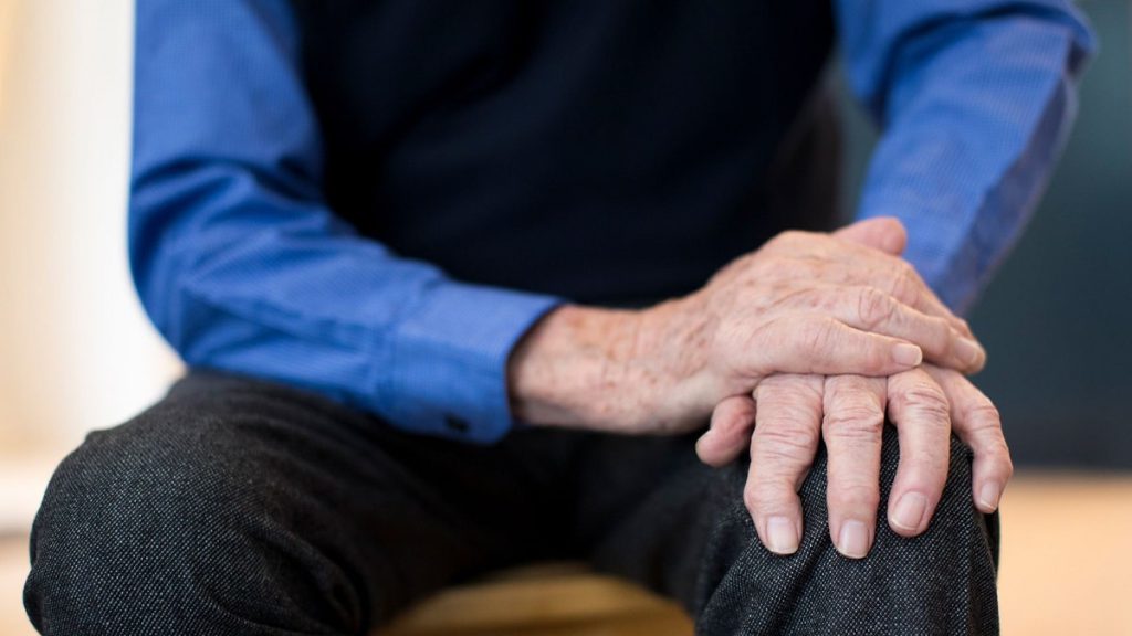 مرد دست زانو نشسته